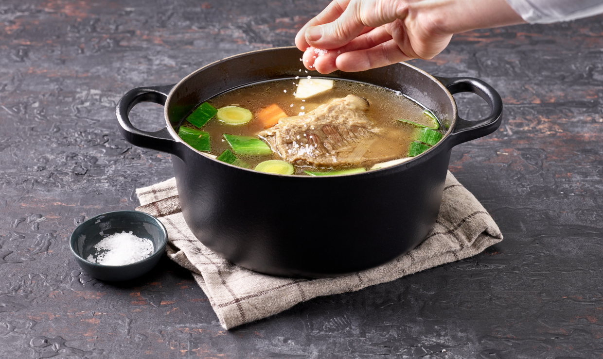 Bouillon im Topf wird gesalzen