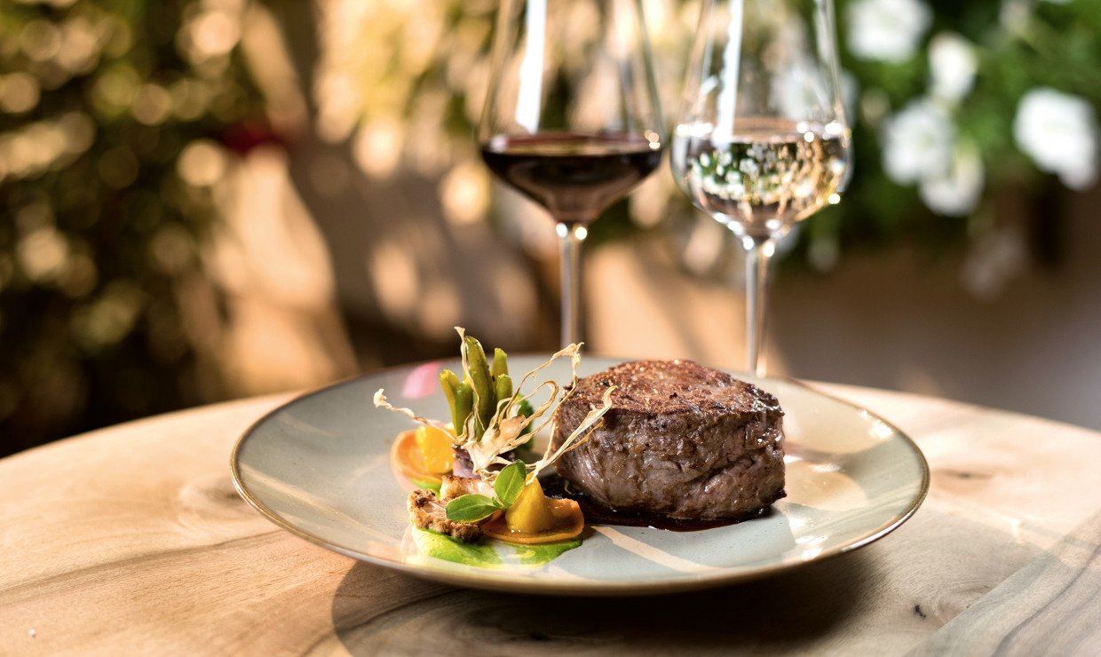 Fleisch auf Teller mit Wein Gläser im Hintergrund