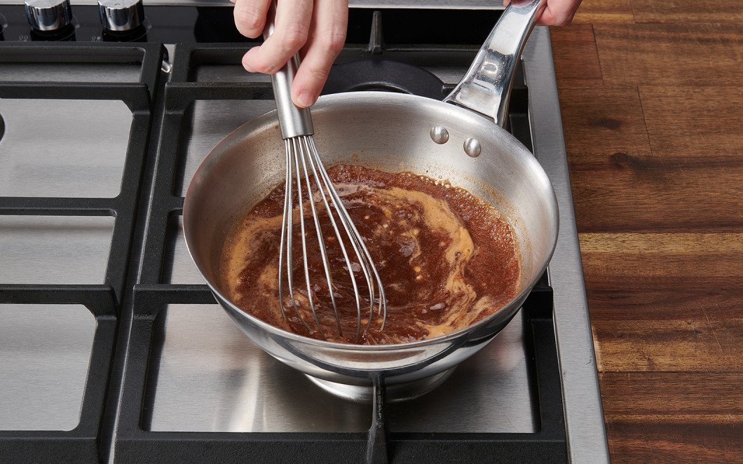 Mit dem Schwingbesen gut weiterrühren, bis die Mehlbutter mit der Sauce abgebunden hat. Reduziere die Hitze und lasse die Sauce auf kleinster Stufe ca. 10 Minuten weiterköcheln.
