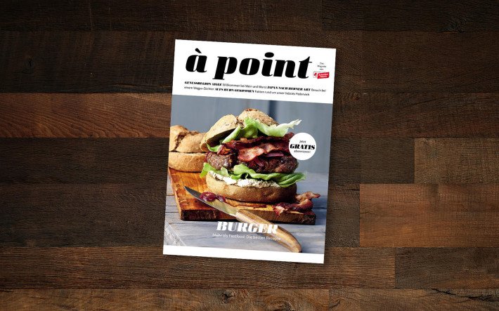 Eine Ausgabe des Magazins «à point» auf einem dunklen Holztisch