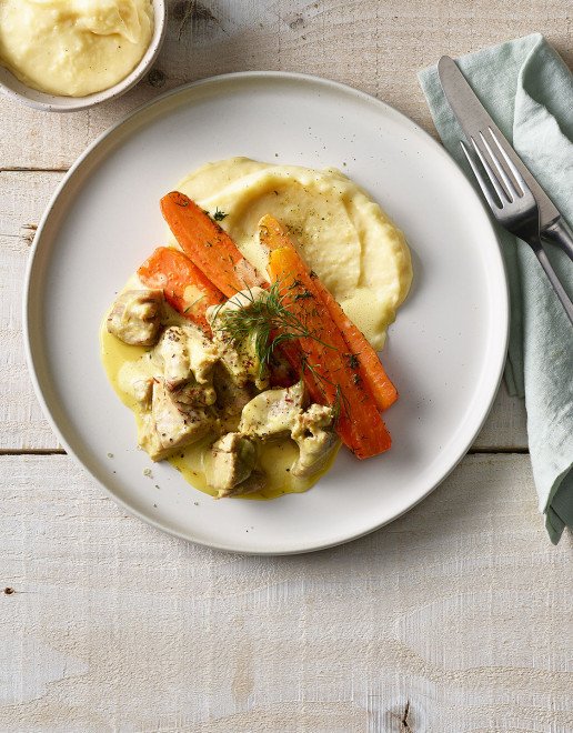 Teller mit Gitzi Ragout an Safran Sauce mit Kartoffelstock und Bundkarotten