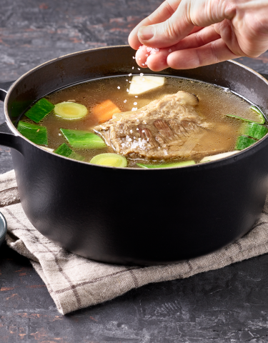 Bouillon im Topf wird gesalzen