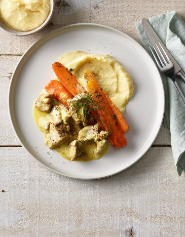 Teller mit Gitzi Ragout an Safran Sauce mit Kartoffelstock und Bundkarotten
